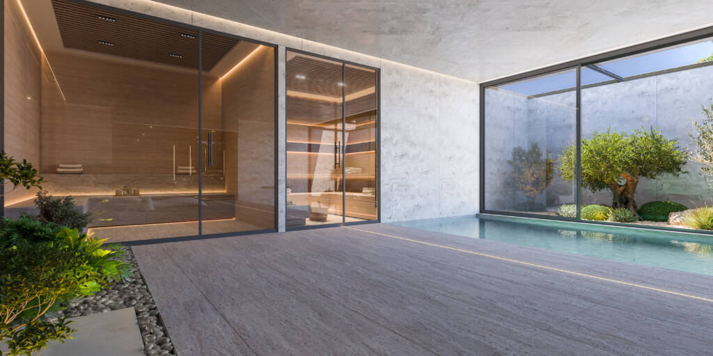 Sauna de madera elegante ubicada junto a una piscina interior, con ventanales grandes que ofrecen vistas relajantes al jardín interior. Al fondo se sitúa una sauna.